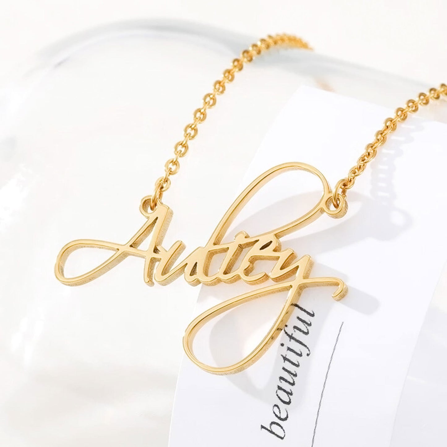 Styled view of gold link chain with a custom-made script name necklace from CustomNameJewelry.com.