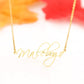 Detail of a gold-tone link chain and a personalized script name necklace.