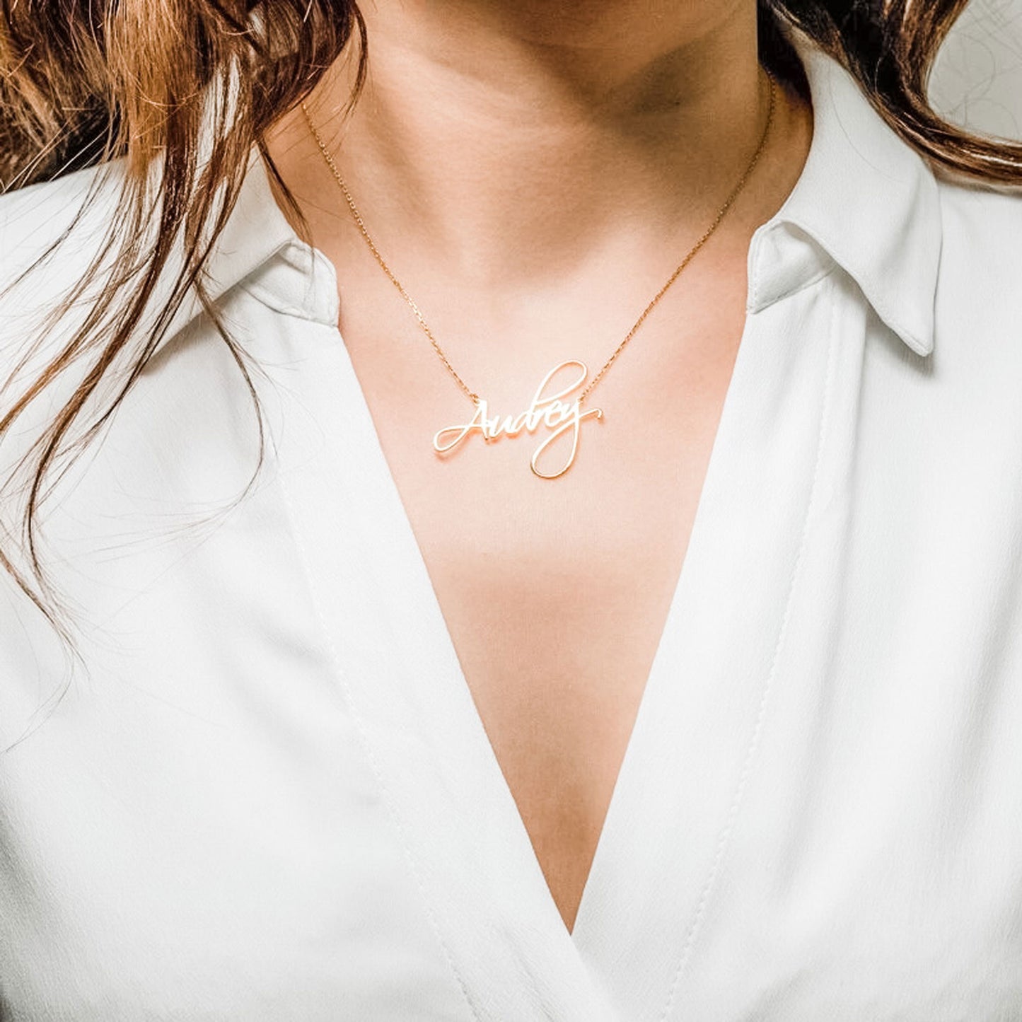 Image of Woman displaying a gold-tone link chain and a custom-engraved script lettering necklace